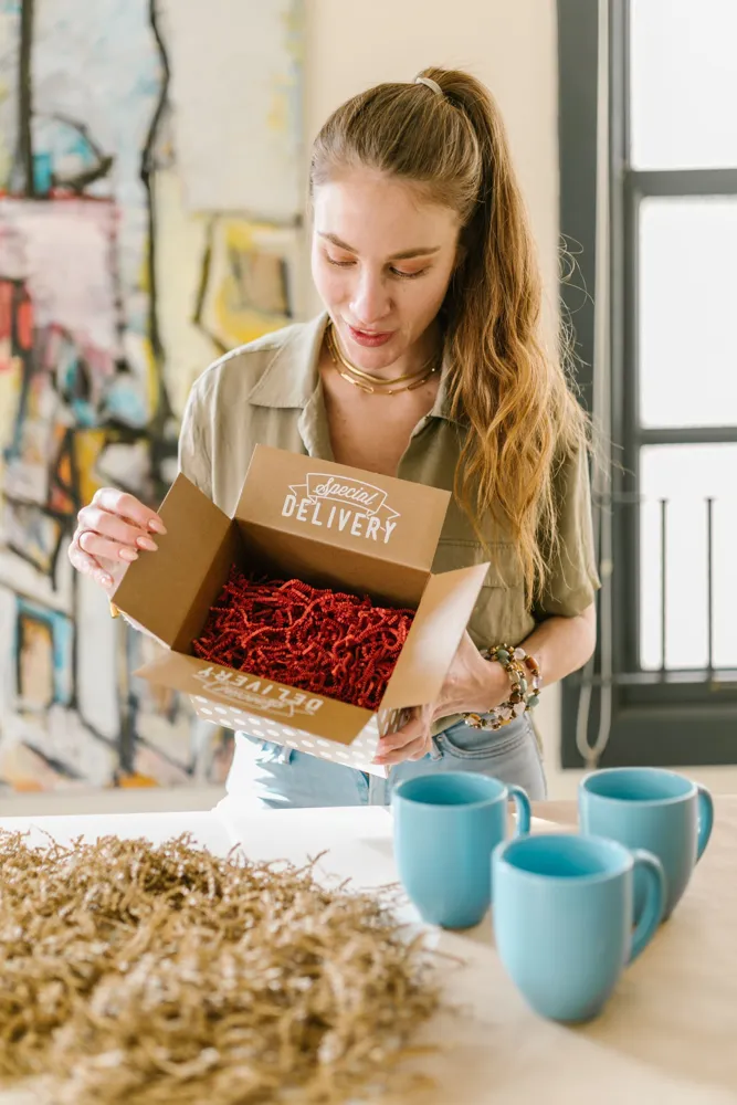Une femme déballe des tasses en céramique