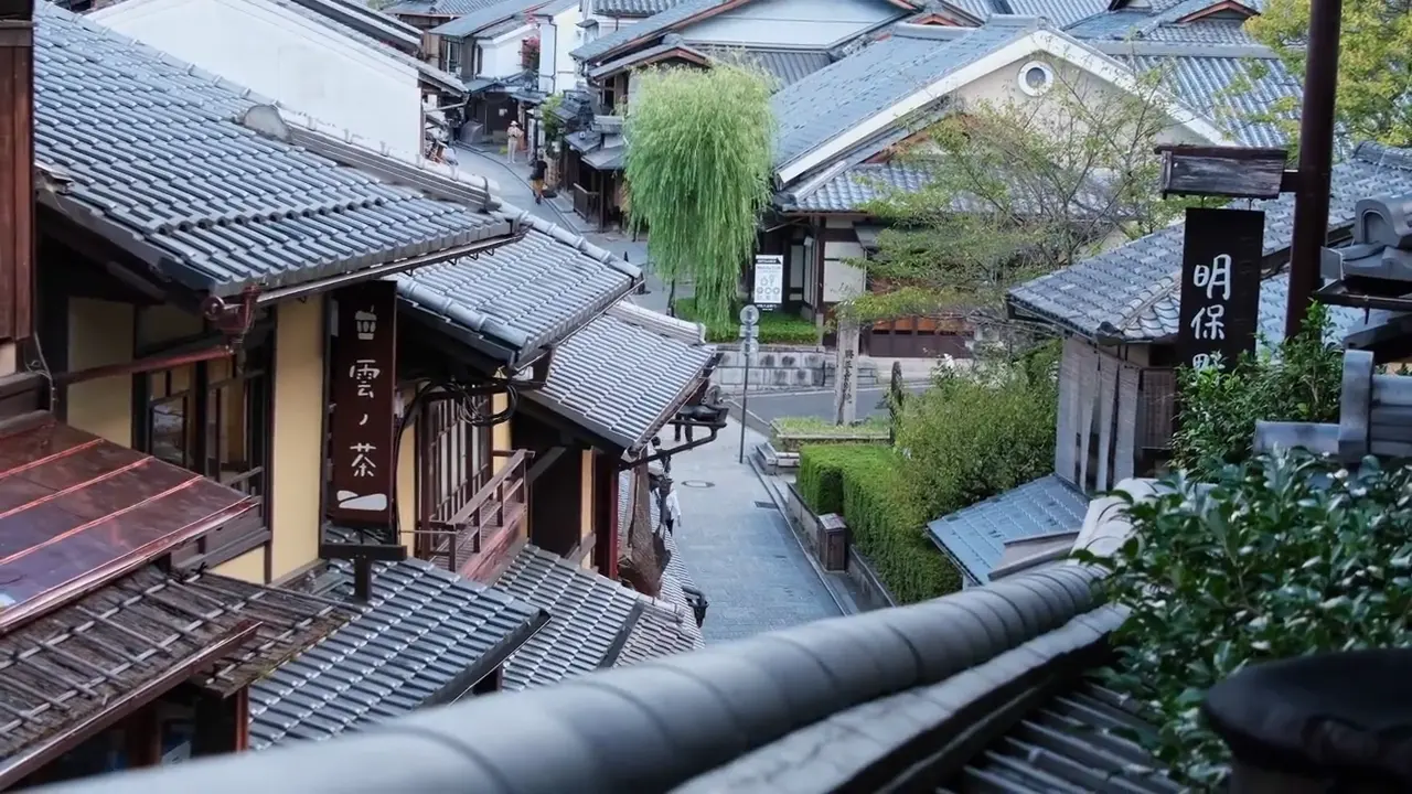 Une rue en pente de Kyoto, ombrelles blanches et maisons de bois